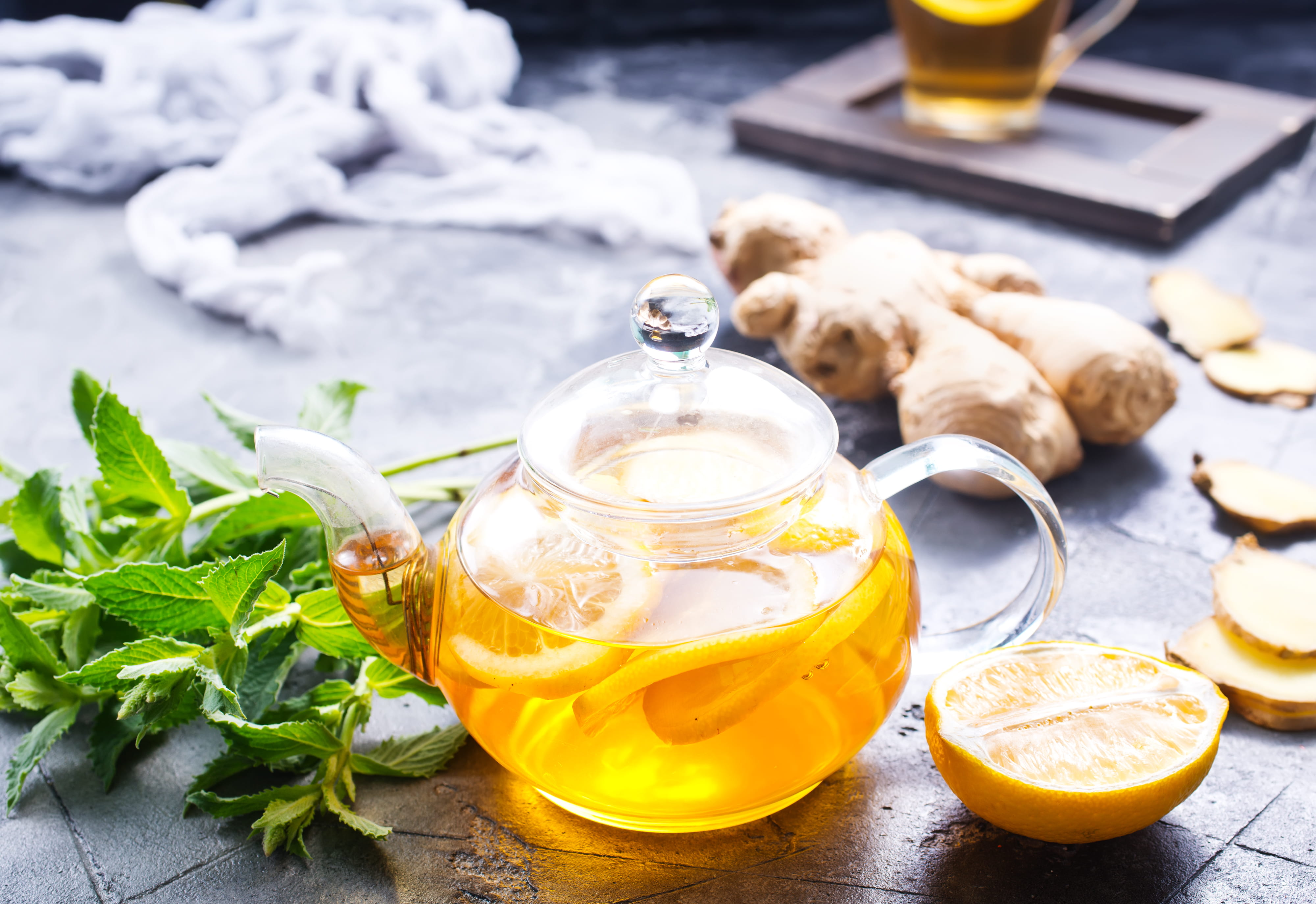 Teekanne mit Kräutern und Orangenscheiben