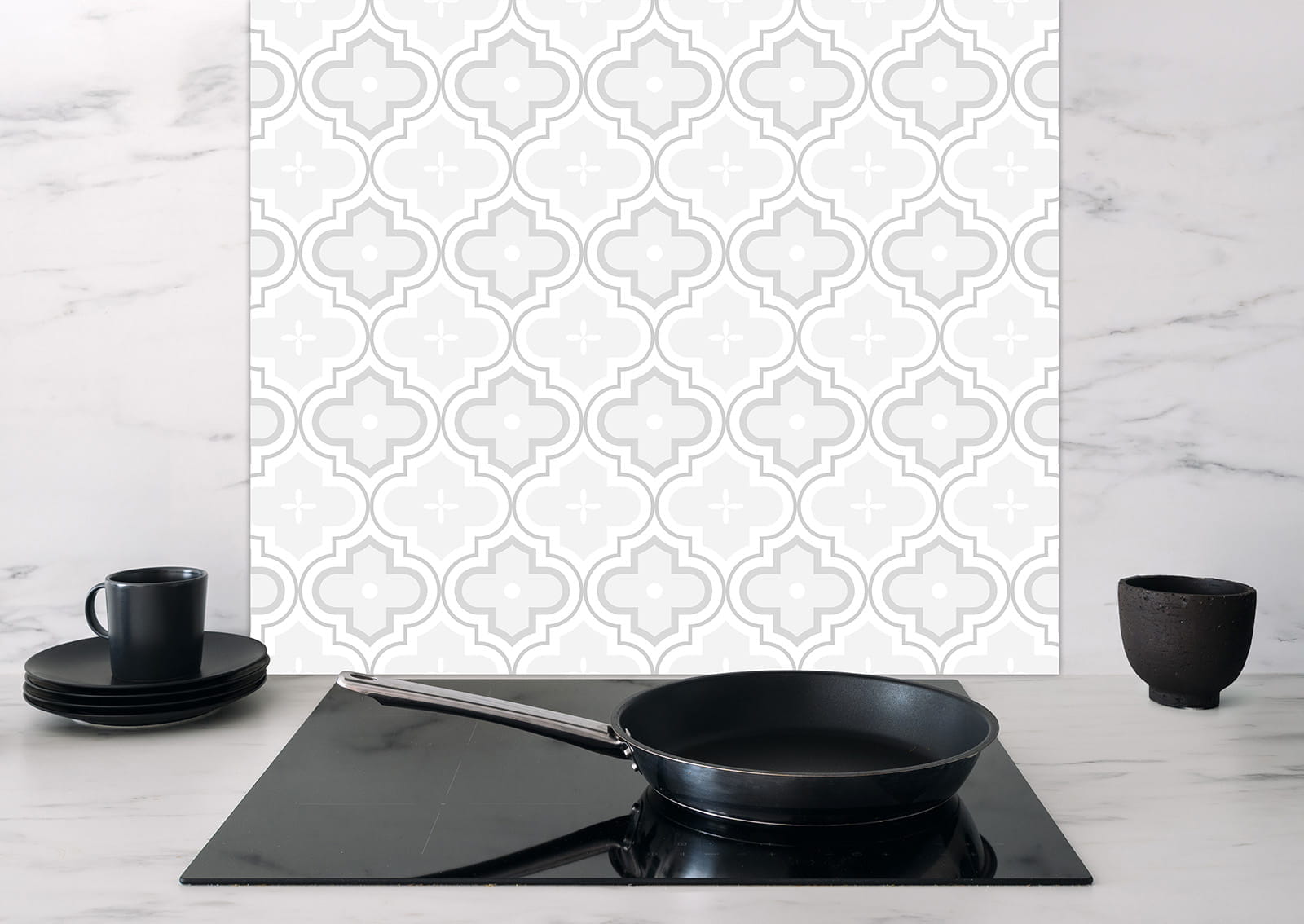 Spritzschutz Marokkanische Fliesen von ENTDECKER mit grauem Mosaikmuster, im Hintergrund eine moderne Küche mit Kochfeld und Geschirr.